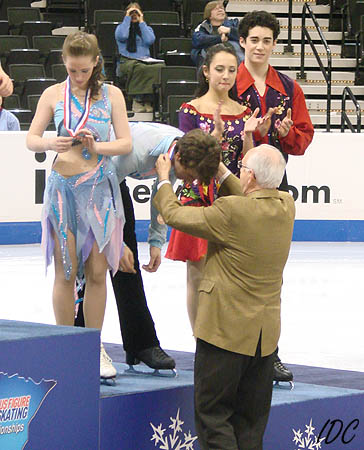 Una checks out her bronze medal while Andrew receives his