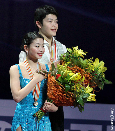 The bronze-medal-winning Shibutanis listen to their National Anthem.